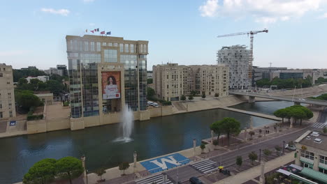 Modern-architectural-building-with-giant-fountain-in-Montpellier-Lez-Aerial-view